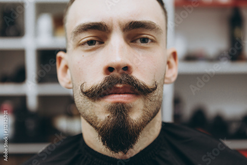 portrait of a satisfied barber shop customer who came to change his beard shape