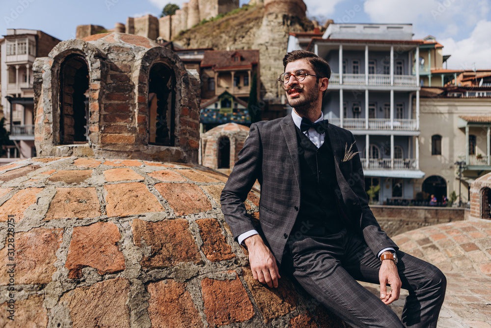 portrait of a stylish authentic Georgian man posing for a photo in the middle of the old city in Tbilisi