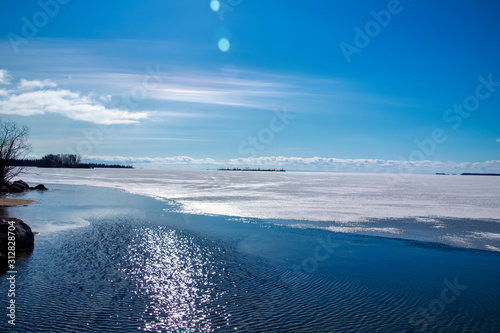 Sunrise on a beautiful cloudless spring morning at Lac La Ronge with the lake ice partially melted