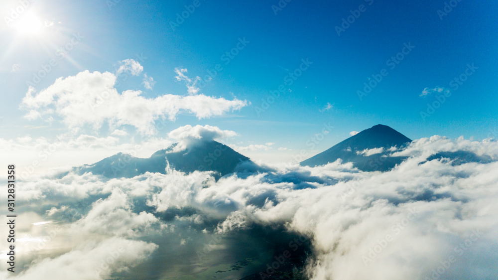 Mountain peaks surrounded by cumulus clouds Mountain peaks surrounded by cumulus clouds