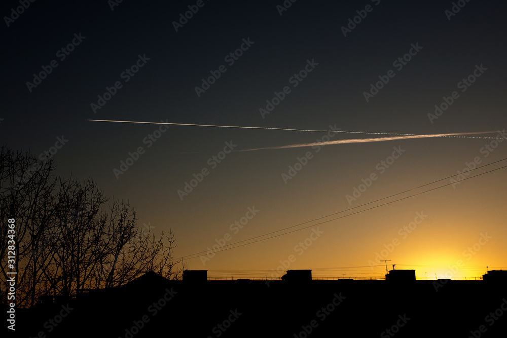 Airplane in the sky at sunset. The plane is in the sky at sunset