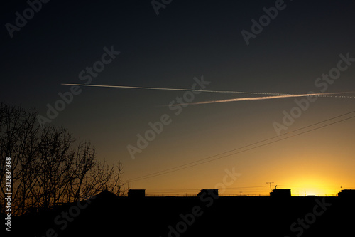 Airplane in the sky at sunset. The plane is in the sky at sunset