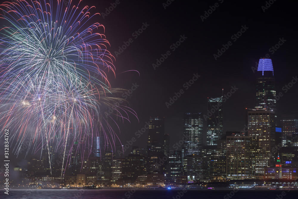 San Francisco waterfront with New Year's Eve 2020 Fireworks. Fireworks display launched from Pier 14 near The Embarcadero in San Francisco, California, USA.