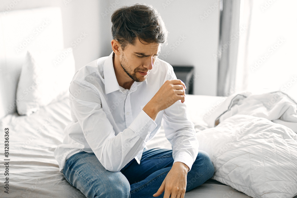 man drinking coffee in bed