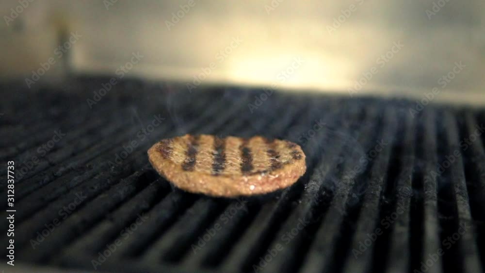 Hamburger patty grilling on BBQ with charcoal marks, Closeup Macro Shot Hamburger patty grilling on BBQ with charcoal marks, Closeup Macro Shot