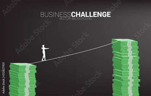 Silhouette of businessman walking on rope walk way to higher banknote stack .Concept for business risk and career path