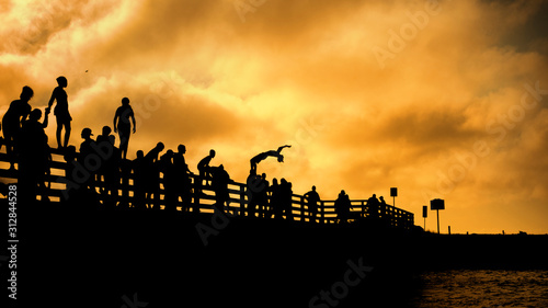 silhouettes of people jumping of Beach Rd jaws bridge martha's vineyard  Edgartown and Oak Bluffs sunset summer sky
