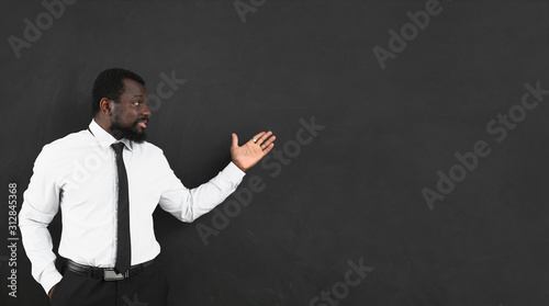 African-American teacher near blackboard in classroom