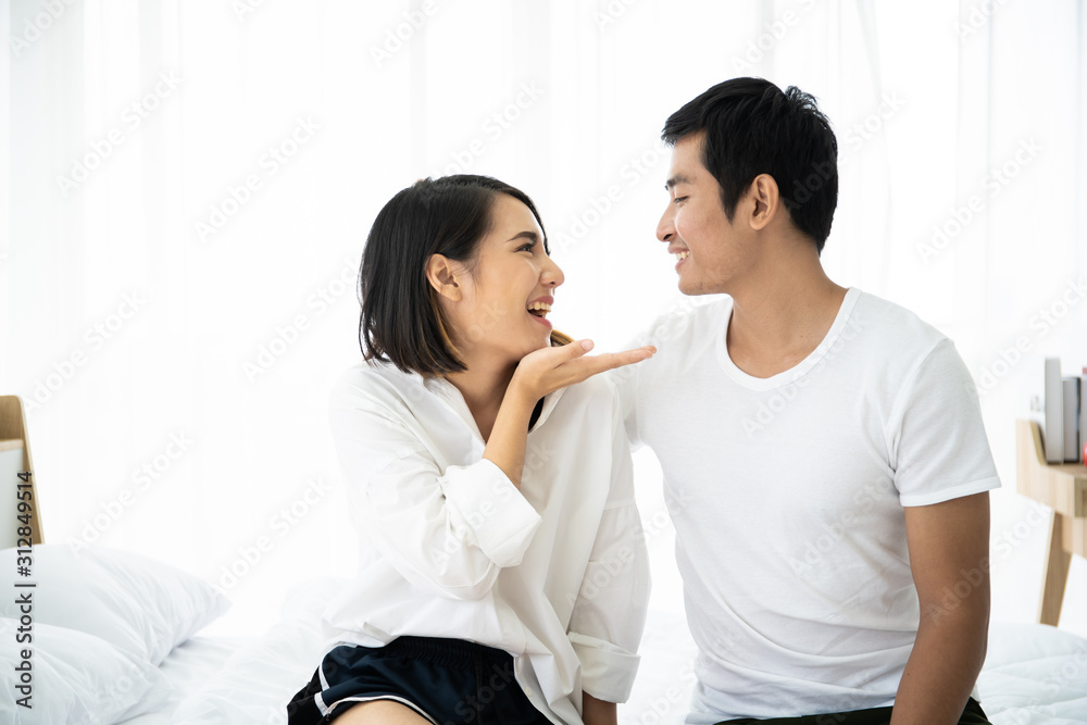 Funny and romantic Asian couple' portrait in bedroom with natural light from window, concept of relationship between husband and wife and being a family. Funny and romantic Asian couple' portrait in bedroom with natural light from window, concept of relationship between husband and wife and being a family.