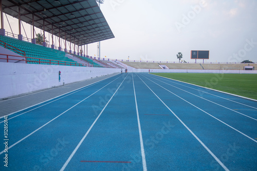 Running track in a rural stadium. People running exercise faces blurred. Which cannot recognize faces.