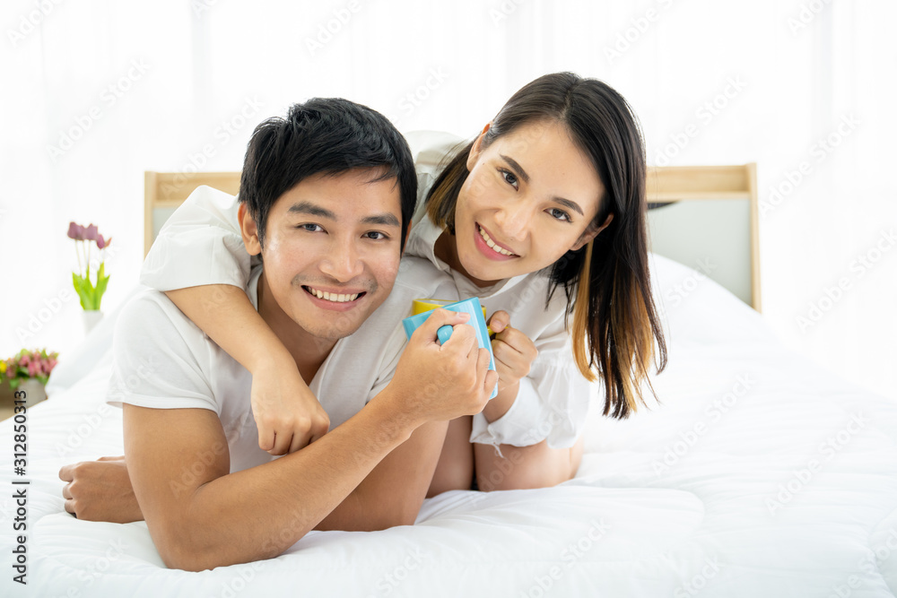 Asian young couple enjoying together with coffee in the morning in badroom, concept of leisure, couple, relationship and valentine. Photograph with copy space. Asian young couple enjoying together with coffee in the morning in badroom, concept of leisure, couple, relationship and valentine. Photograph with copy space.