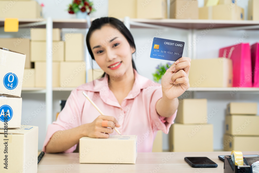 Beautiful young Asian woman in e-commerce and online shopping concept, happy woman showing up the fake credit card. Beautiful young Asian woman in e-commerce and online shopping concept, happy woman showing up the fake credit card.