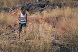 dry grass field with blurred background of african american woman having exerice with trail running at natural mountain