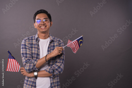 Happy Malaysian teenager holding Malaysia Flag.Independence day and patriotic concept.Studio Shot.