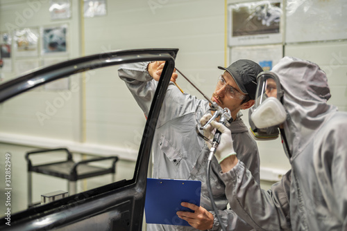 An employee of the paint shop of the automobile plant conducts training on applying sealant