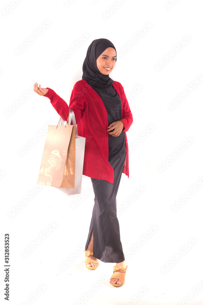 Happy young Muslim girl holding shopping bags isolated over white background. Happy young Muslim girl holding shopping bags isolated over white background.