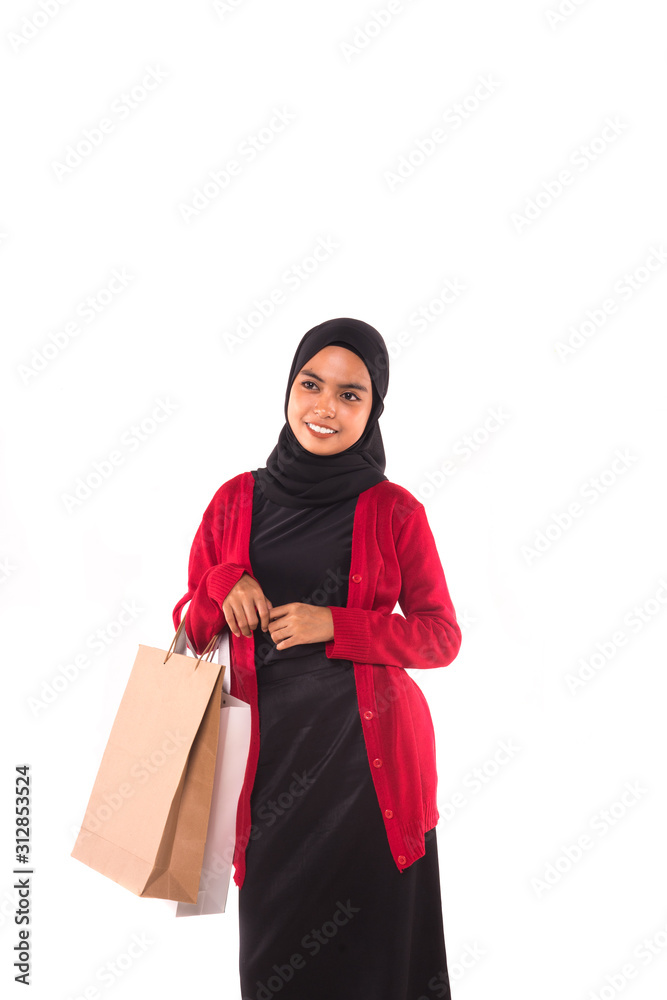 Happy young Muslim girl holding shopping bags isolated over white background. Happy young Muslim girl holding shopping bags isolated over white background.