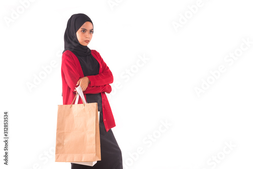 Happy young Muslim girl holding shopping bags isolated over white background.
