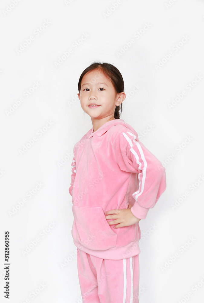 Adorable little Asian child girl in pink tracksuit or sport cloth doing exercises over white background. Adorable little Asian child girl in pink tracksuit or sport cloth doing exercises over white background.