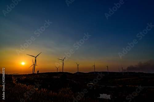 Wind turbine farm over sunset