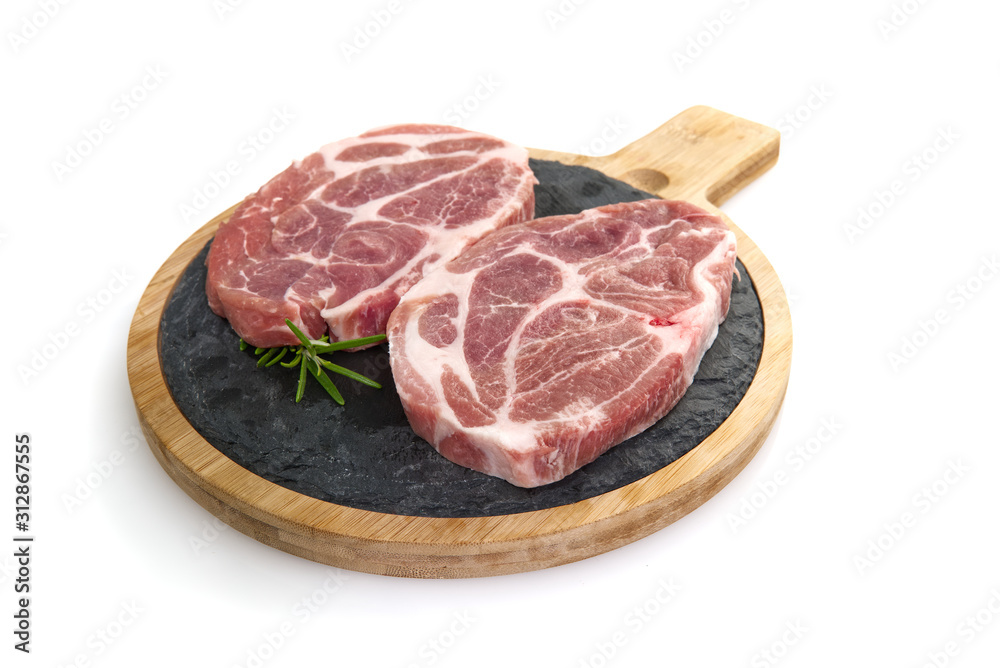 raw pork slices on black stone plate, isolated on white.
