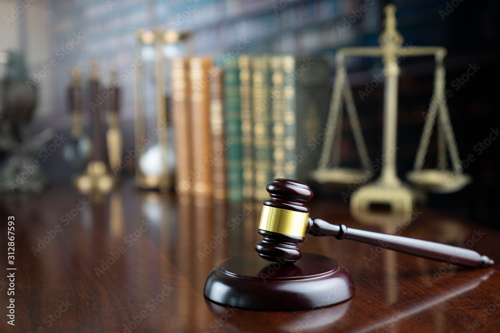 Law and justice theme, judge’s gavel and the scale on court library background Law and justice theme, judge’s gavel and the scale on court library background