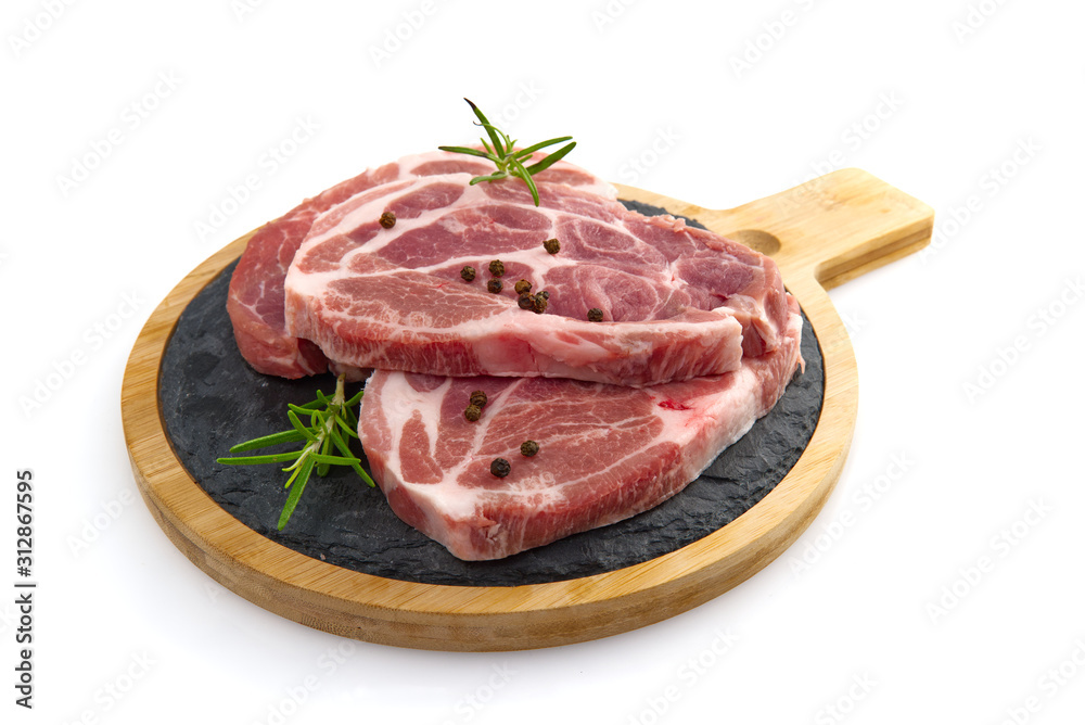 raw pork slices on black stone plate, isolated on white.