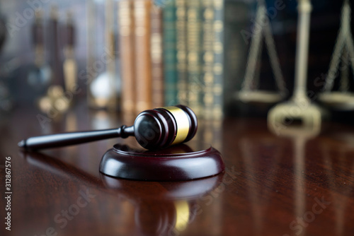 Law and justice theme, judge’s gavel and the scale on court library background photo