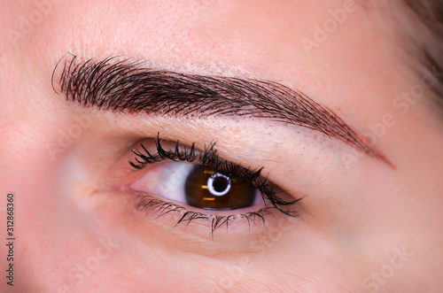 Microblading eyebrows, getting facial care and tattoo at beauty salon photo
