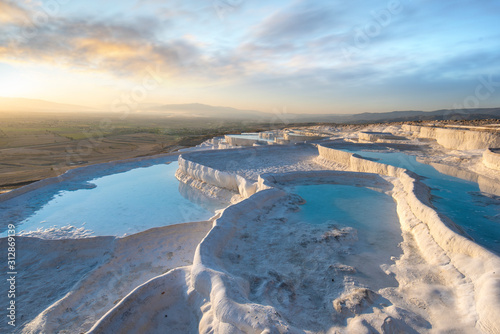 Beautiful sunset and Natural travertine pools and terraces in Pamukkale. Cotton castle in southwestern Turkey near Denizli, Hot springs white colored with turquoise blue water used like a bath