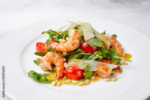 salad with shrimp, tomatoes, arugula, lettuce, beans, laid out on a white plate