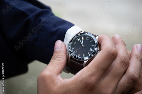 looking at luxury watch on hand check the time.concept for managing time organization working,punctuality,appointment.fashionable wearing stylish
