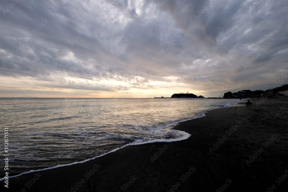 sunset of Enoshima island in Kanagawa Japan. Sea waves against beach. Wide angle