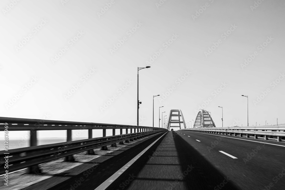 view of the road communication of the Crimean bridge from a moving car on a summer day. black and white photo