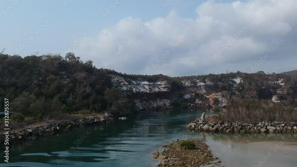 Aerial video of a ocean inlet leading to a large estuary surrounded by rugged sandstone cliffs Aerial video of a ocean inlet leading to a large estuary surrounded by rugged sandstone cliffs