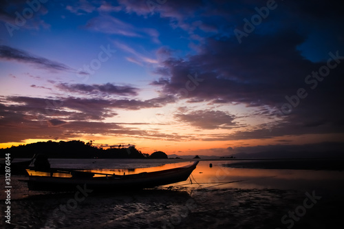 Beautiful Sky and sunset on the beach with Fishing boat silhouette.