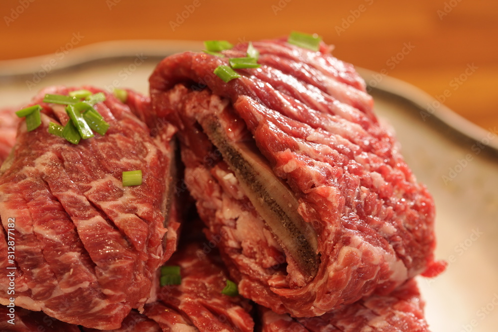 Korean beef, called 'ribs', is placed on a plate with various side dishes(갈비라고 불리는 한우는 다양한 반찬이 담긴 접시에 담겨 있습니다)