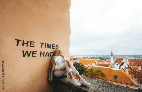 A young blonde female tourist inspects an city from bird 's flight altitude. photo