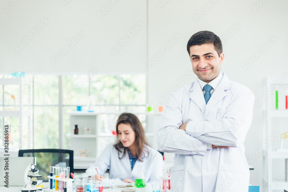 Smiling scientist leaning against the whiteboard in laboratory Smiling scientist leaning against the whiteboard in laboratory