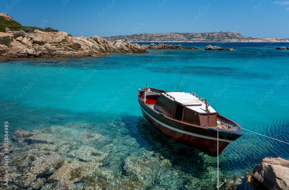 small boat in the turquoise sea in Sardinia