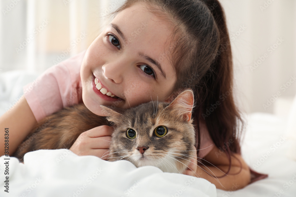 Cute little girl with cat lying on bed at home. First pet Cute little girl with cat lying on bed at home. First pet