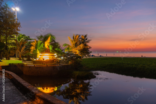 sunset behind golden dragon statue on Karon beach Phuket Thailand