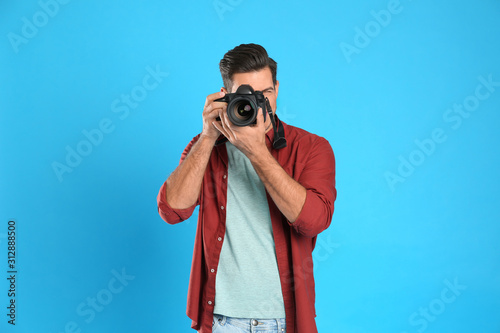Professional photographer working on light blue background in studio