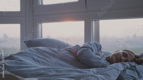 Beautiful romantic brunette woman sleeping on bed by the window