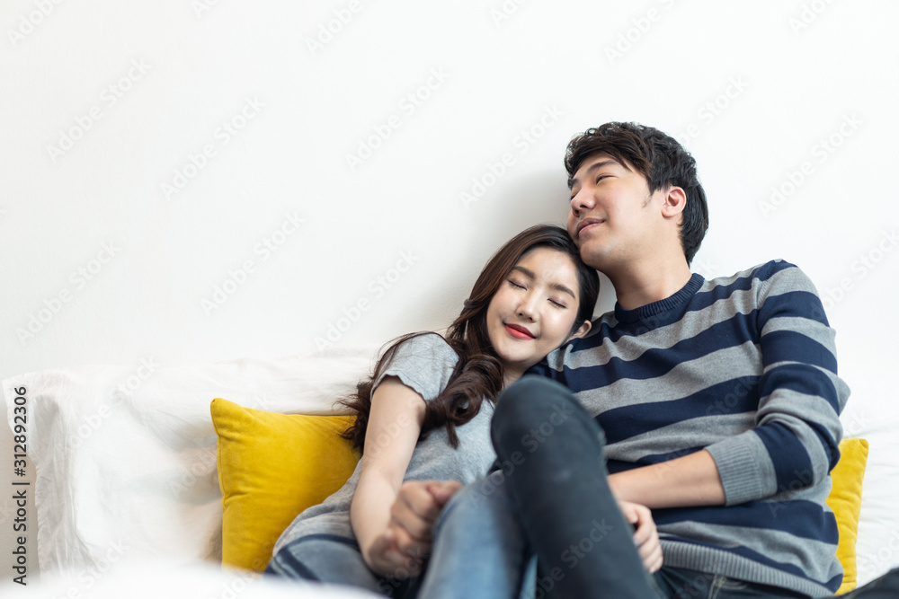 Asian young couples man and woman staying together in bed room. Girl putting head on boyfriend shoulder and closing eyes feeling love happy with smile face. Relationship of young girl and boy concept. Asian young couples man and woman staying together in bed room. Girl putting head on boyfriend shoulder and closing eyes feeling love happy with smile face. Relationship of young girl and boy concept.