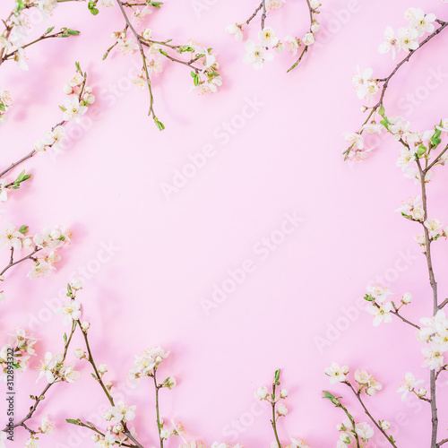 Floral frame with spring flowers isolated on pink background. Flat lay