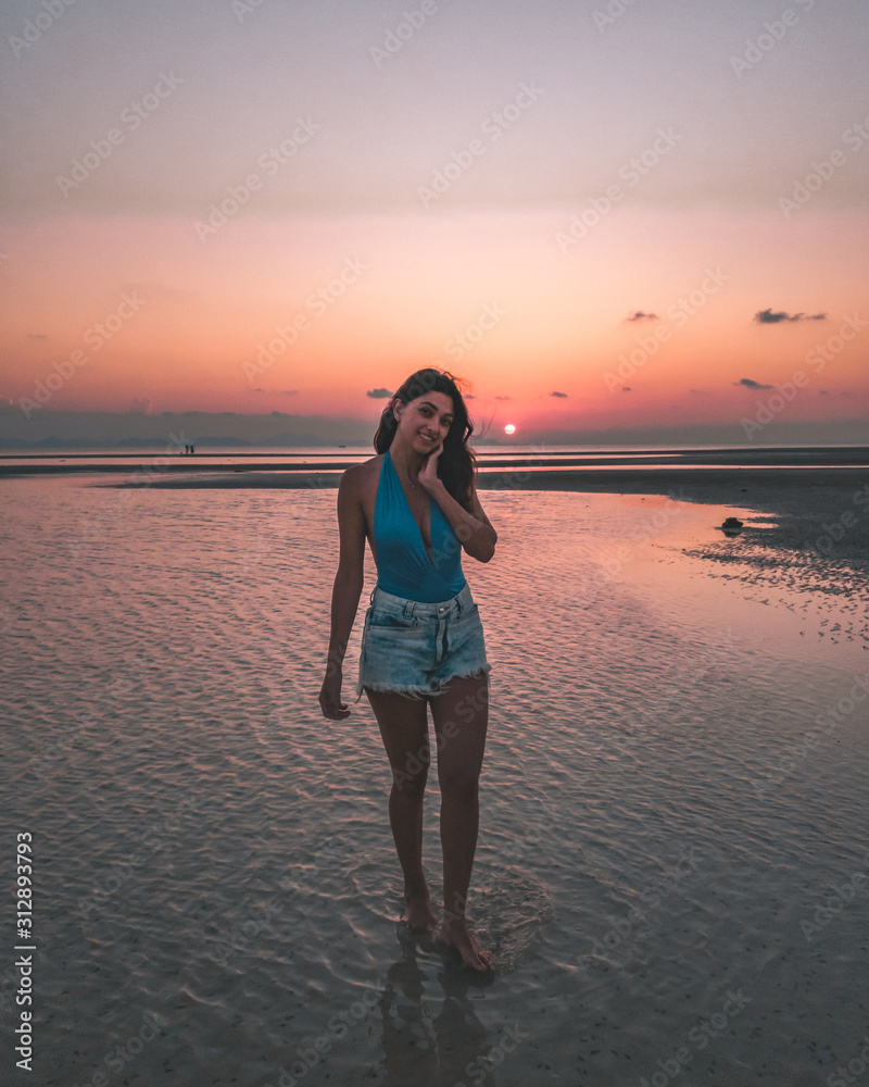 Pink sunset in thailand with a girl on palm trees