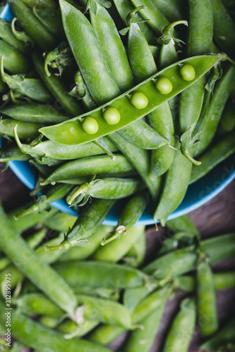 Fresh green peas on a wooden table