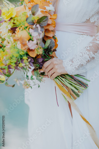 La mariée tenant son bouquet de fleurs dans ses mains