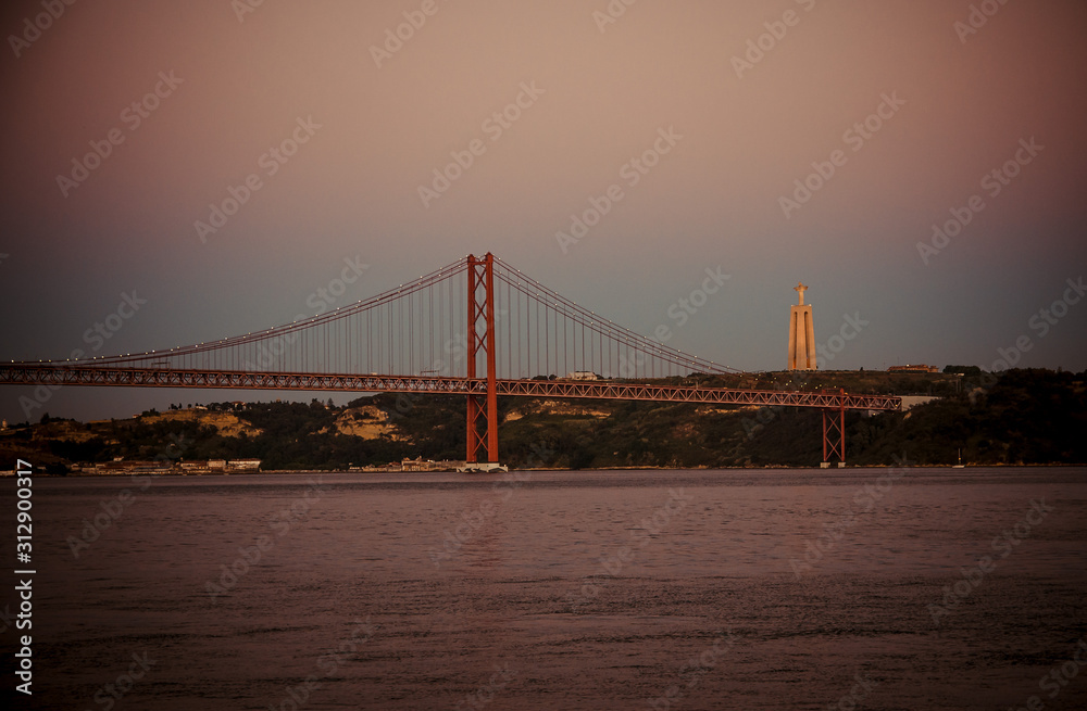 Portugal, Lisbon, evening landscape of Tagus river Lisbon, Ponte April 25th bridge over Tagus river, Lisbon on the Tagus river bank, Christ The King Statue over Lisbon